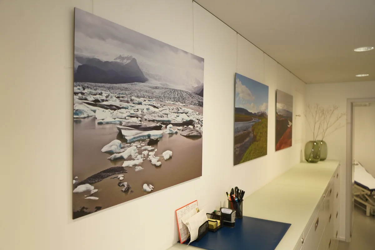 Man sieht Landschaftsbilder an Praxiswänden.